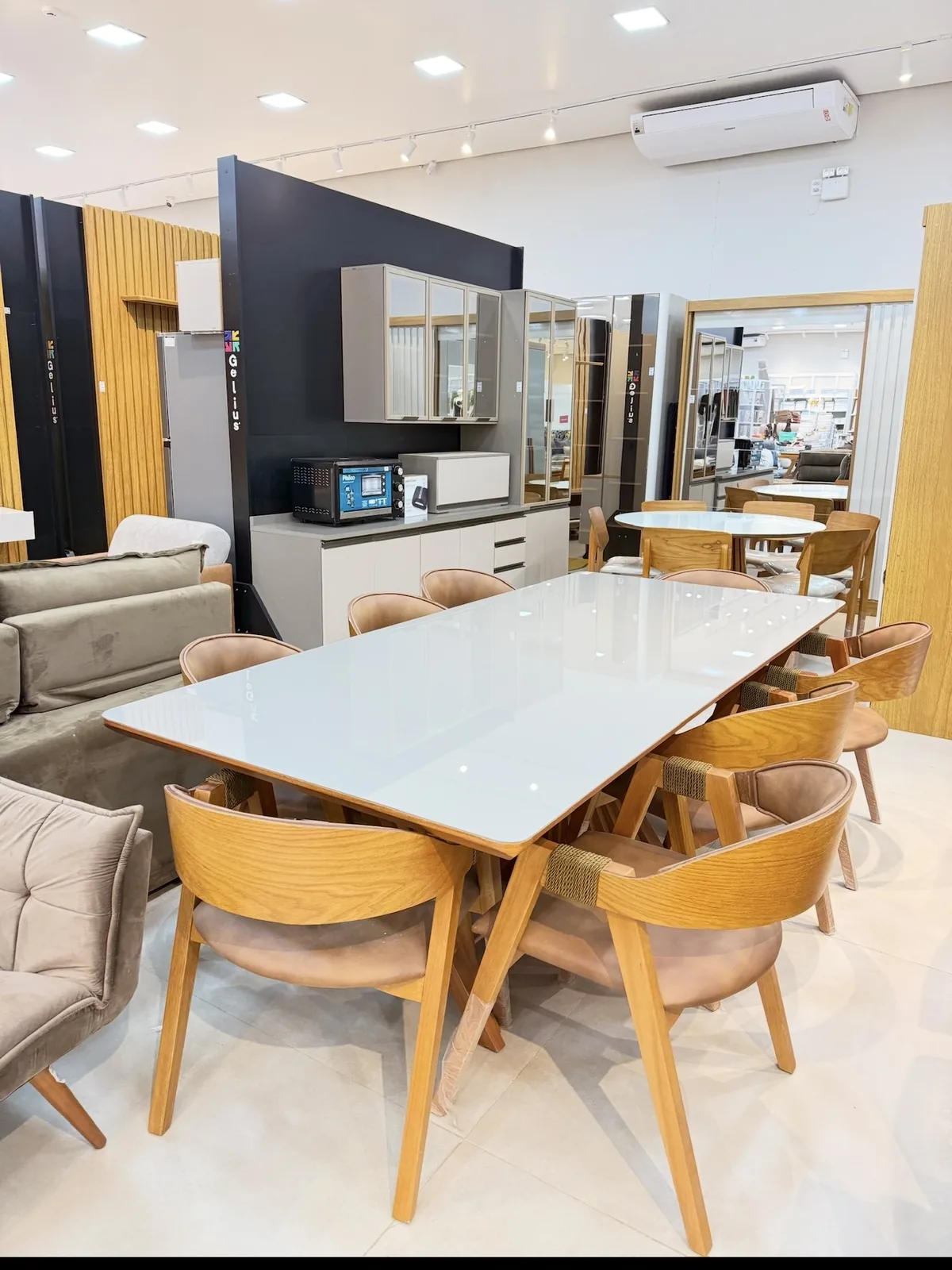 Mesa com cadeiras de madeira no showroom da Maranata
